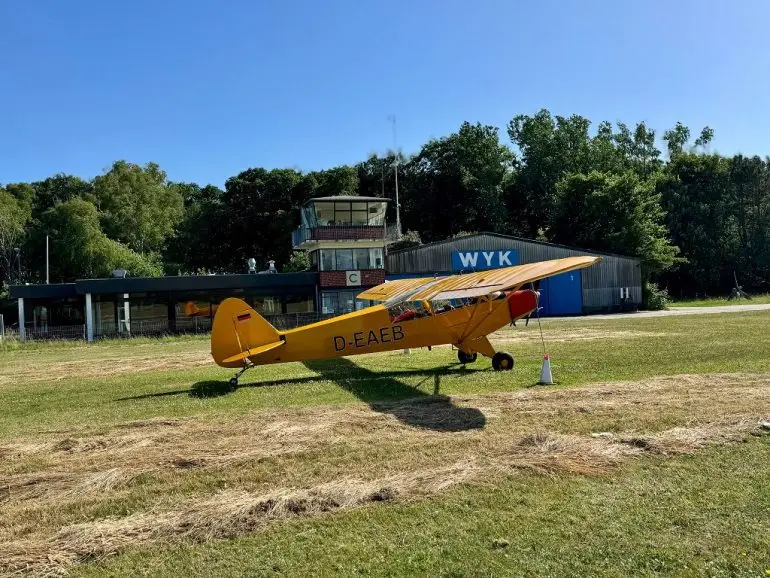 Ein einmotoriges Flugzeug steht auf der Start und Landebahn in Wyk