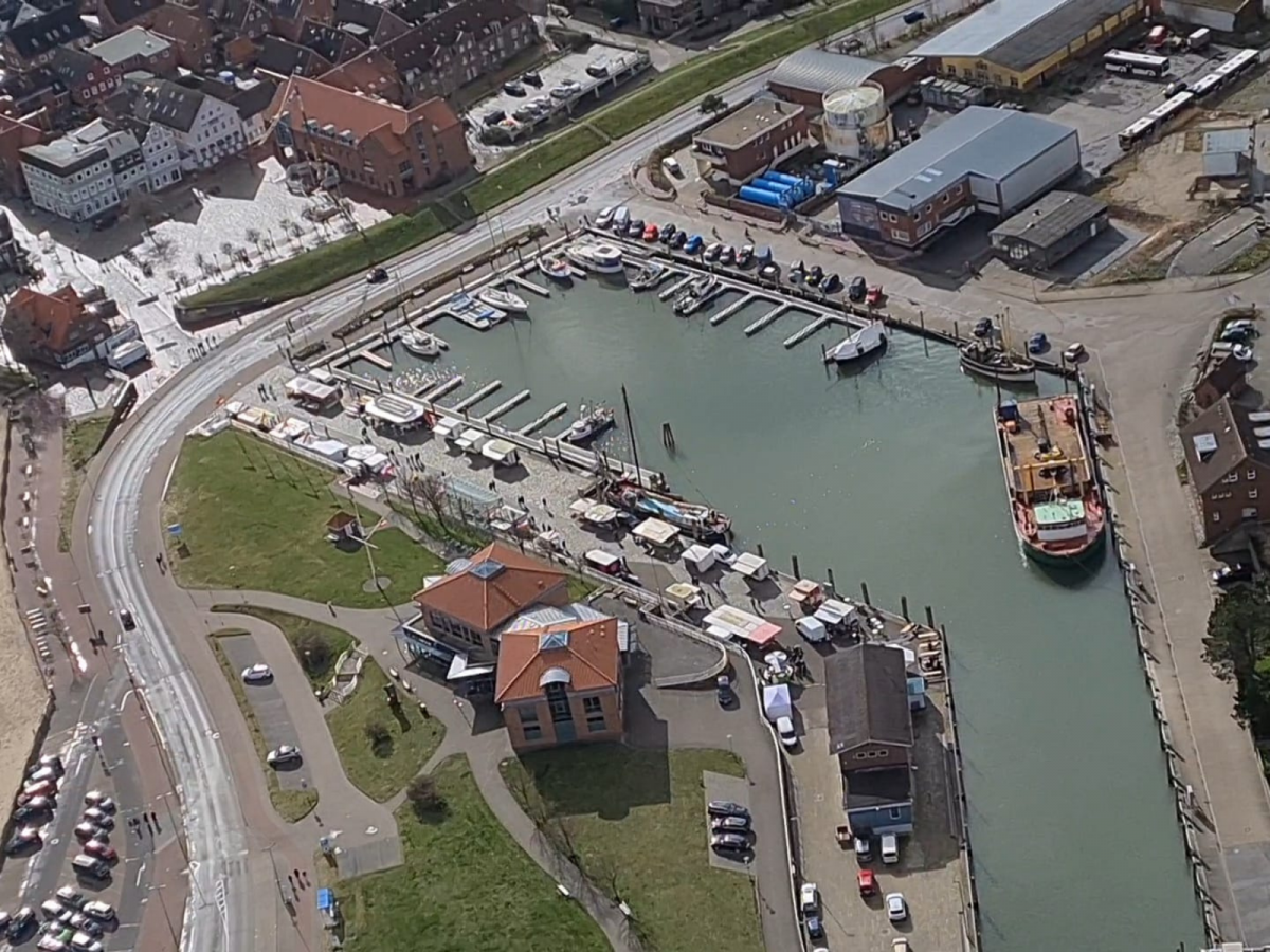 Besucher bummeln über den Wyker Fischmarkt am Hafen in Wyk auf Föhr.