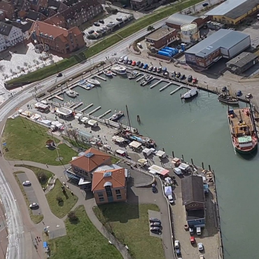 Besucher bummeln über den Wyker Fischmarkt am Hafen in Wyk auf Föhr.