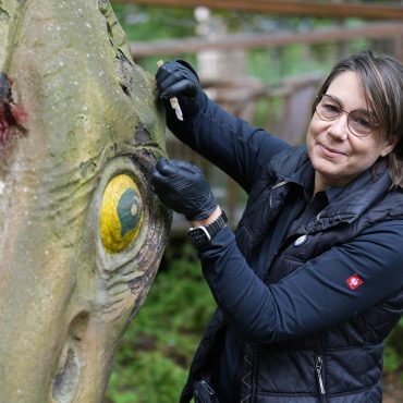Christiane Maier untersucht die Farbschichten der Skulptur.