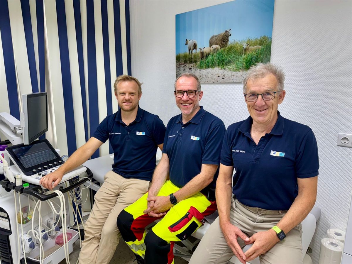 Dr. Hark Weber, Dr. Thies Weber und Dr. Moritz Hemicker vor der Praxis im Meer in Utersum.