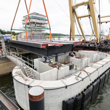 Ein wichtiges Stück der neuen Brücke wird vom Schwimmkran an die richtige Position gehoben.