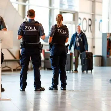 Beamten kontrollieren einzelne Passagiere.