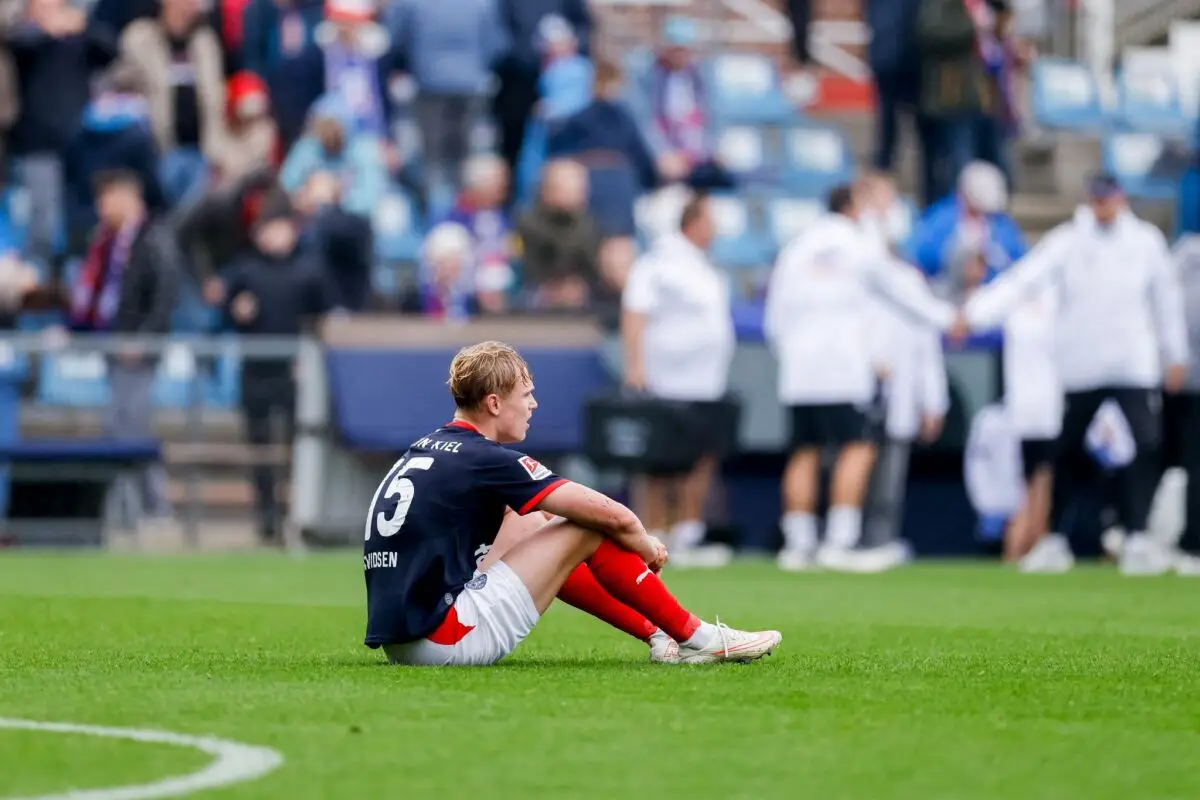Entäuscht sitzt der Kieler Kasper Davidsen nach dem Abpfiff auf dem Rasen.