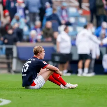 Entäuscht sitzt der Kieler Kasper Davidsen nach dem Abpfiff auf dem Rasen.