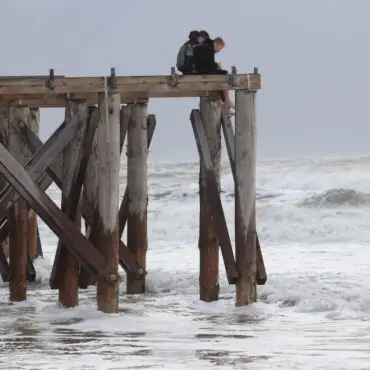 Zwei Jungen beobachten auf der Insel Norderney von oben die stürmischen Wellen.