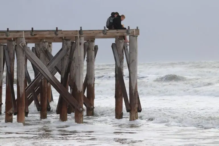 Zwei Jungen beobachten auf der Insel Norderney von oben die stürmischen Wellen.