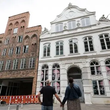 Passanten betrachten das geschlossene Buddenbrookhaus in der Lübecker Altstadt.