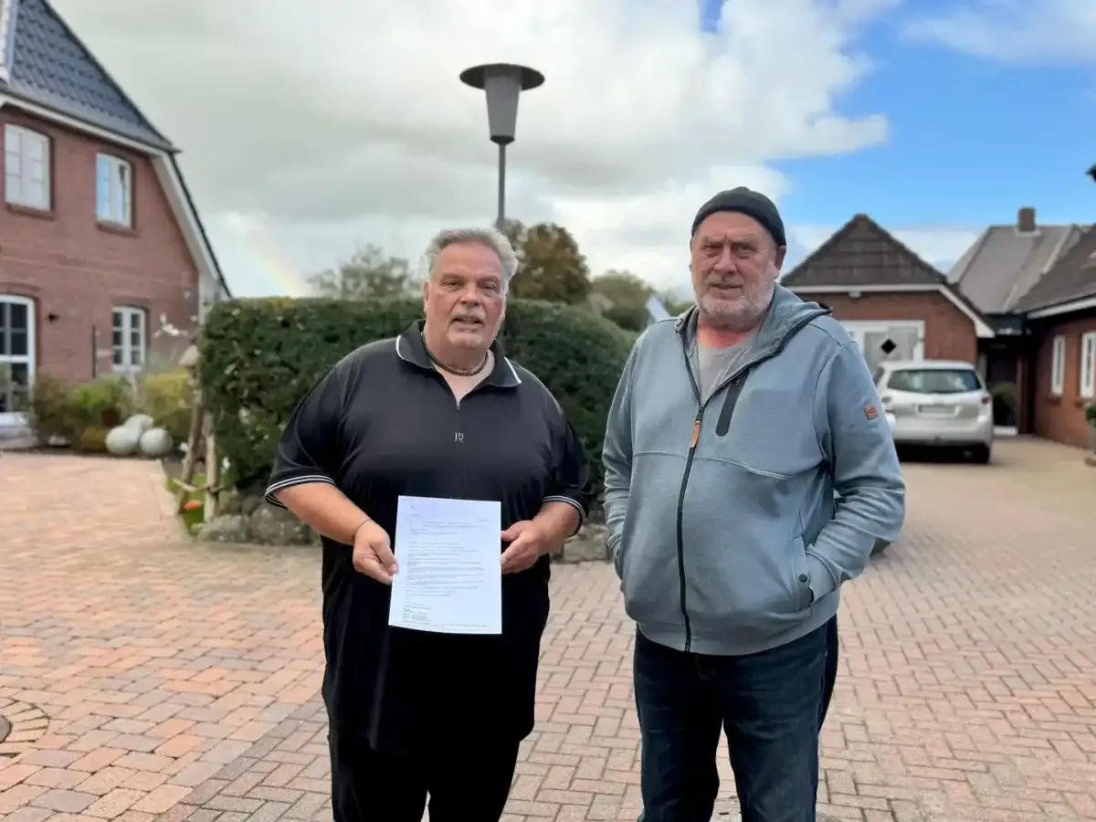 Lothar Schmidt (links) und Michael Schlender in Borgsum auf Föhr – Schmidt hält seine Auftragsbestätigung für den Glasfaseranschluss von Lünecom in der Hand