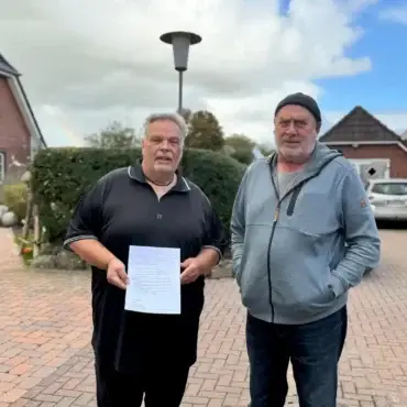 Lothar Schmidt (links) und Michael Schlender in Borgsum auf Föhr – Schmidt hält seine Auftragsbestätigung für den Glasfaseranschluss von Lünecom in der Hand