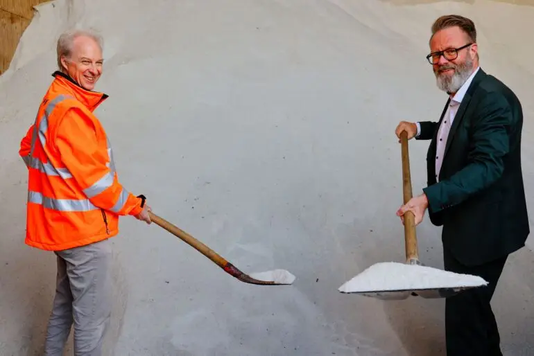 Schleswig-Holsteins Verkehrsminister Claus Ruhe Madsen (CDU, rechts) schaufelt mit Sönke Klettner vom Landesbetrieb Straßenbau und Verkehr schon mal etwas Streusalz.